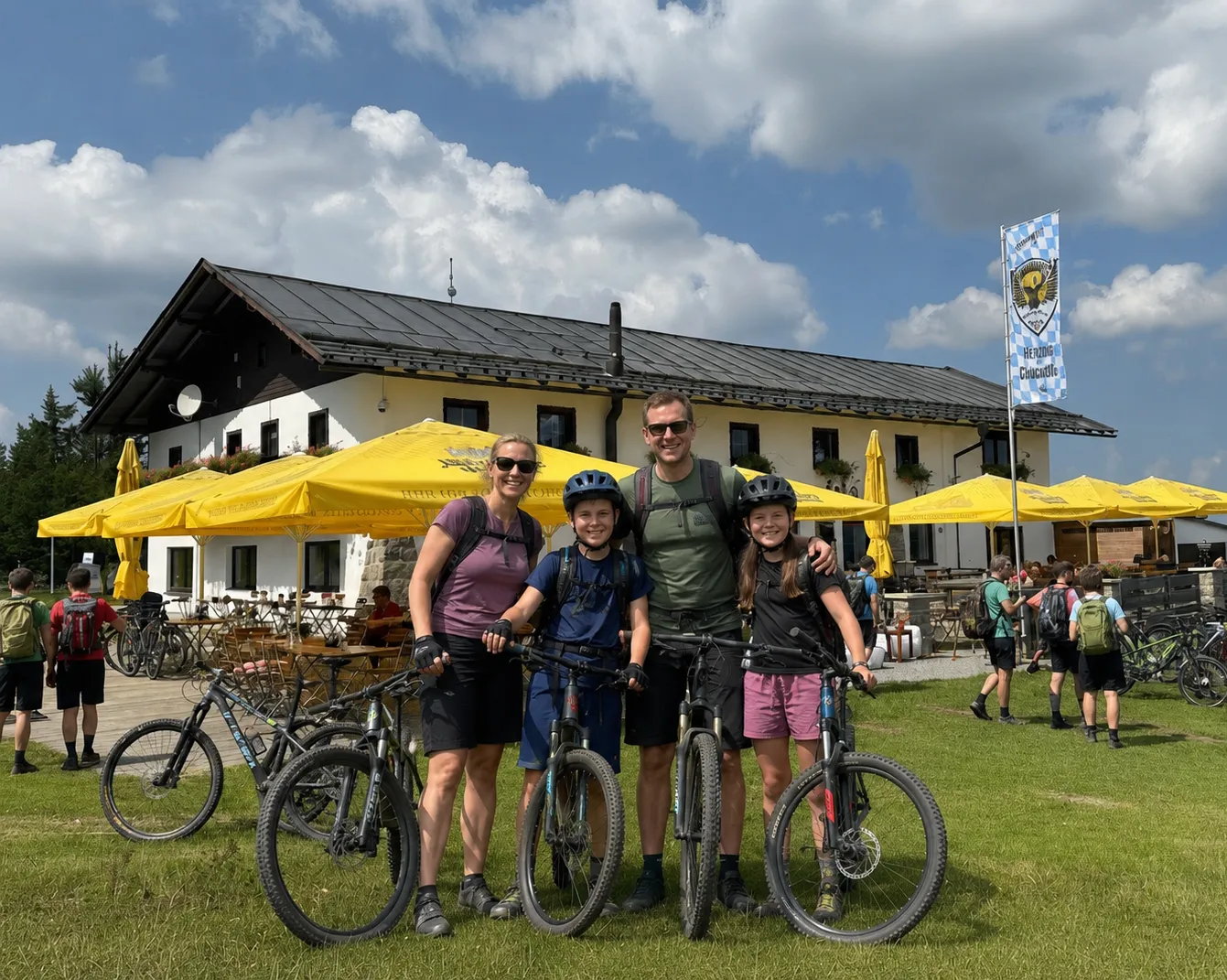 Mountainbike-Familie vor dem Berghaus Sonnenfels
